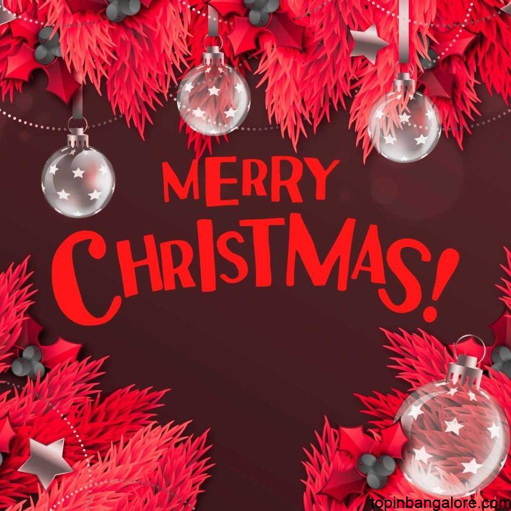 Merry cristmas written in bold letter with white color and red decoration backround and some artificial light bulbs.