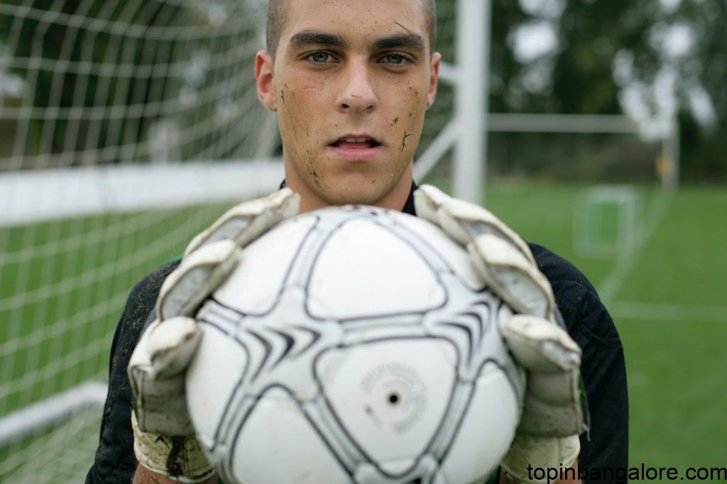 photo of a goalkeeper keeping a ball