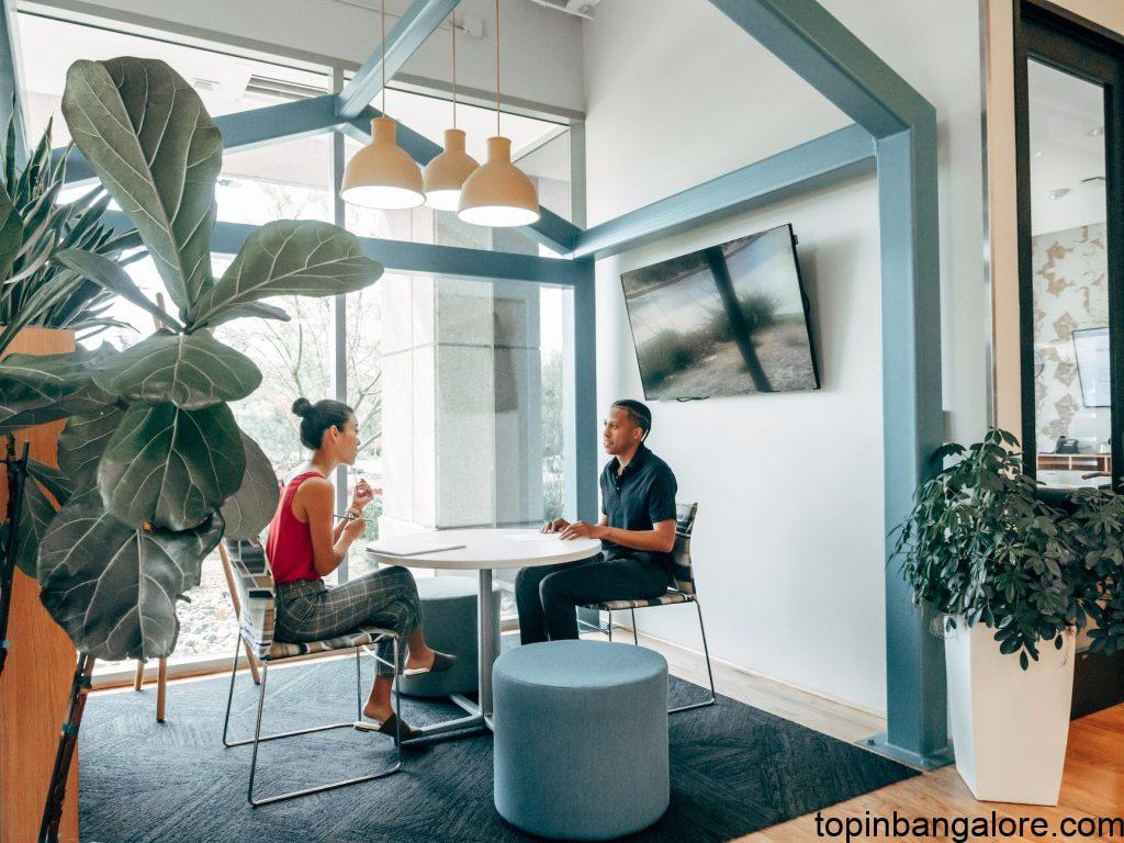 a man and woman sitting on the chair while looking at each other for business ideas